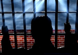 silhouette of a person behind bars